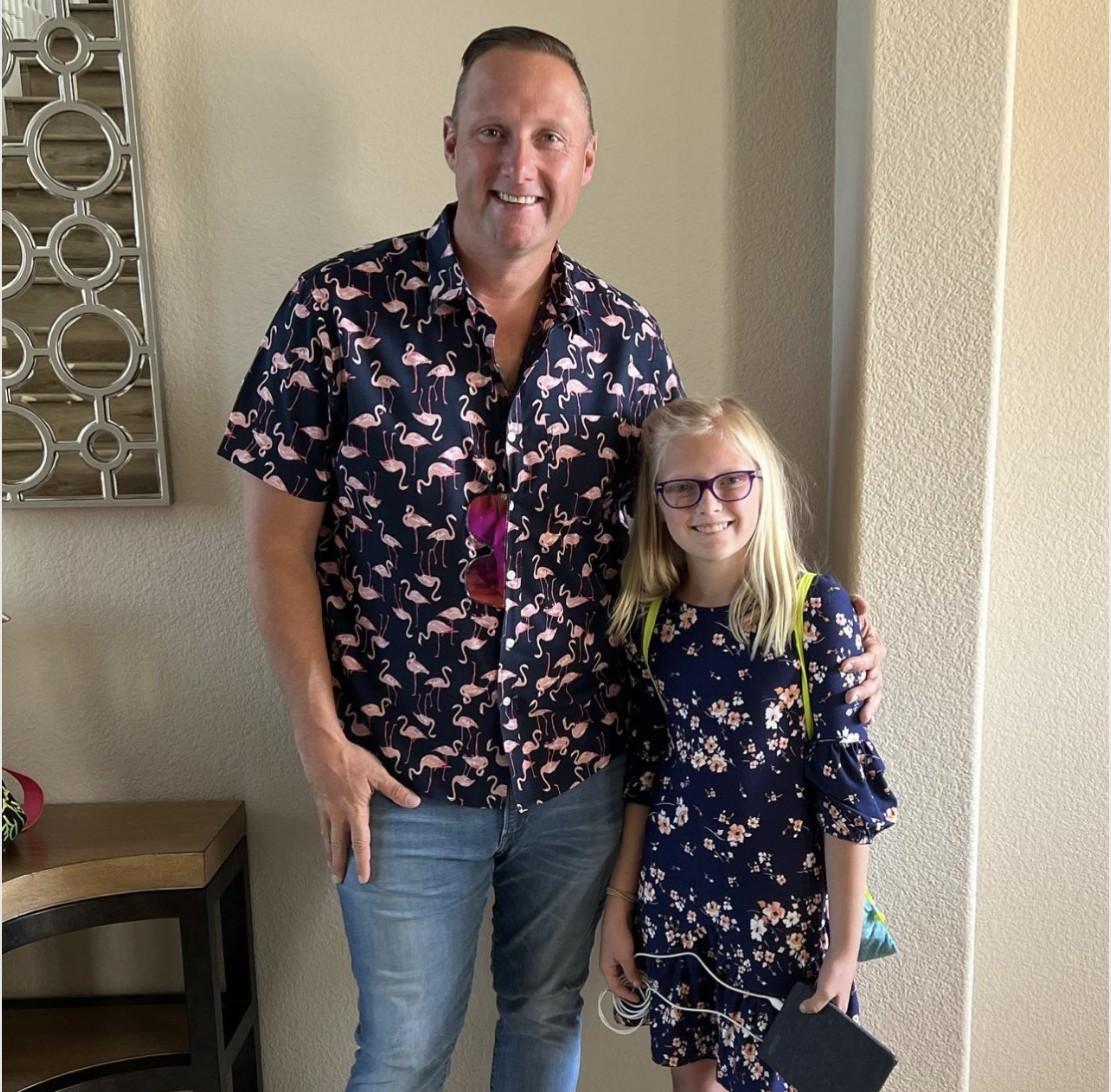 Wayne Partello poses with his daughter at home after bringing her to work for the day.