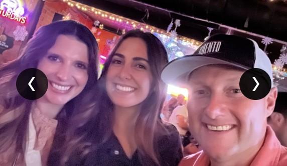 Wayne Partello, wearing a CUENTO cap, smiling with two teammates at a bar.