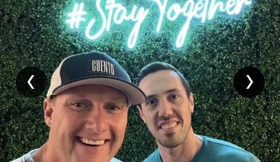 Wayne Partello wearing a CUENTO cap taking a selfie with a teammate in front of the "#StayTogether" sign.