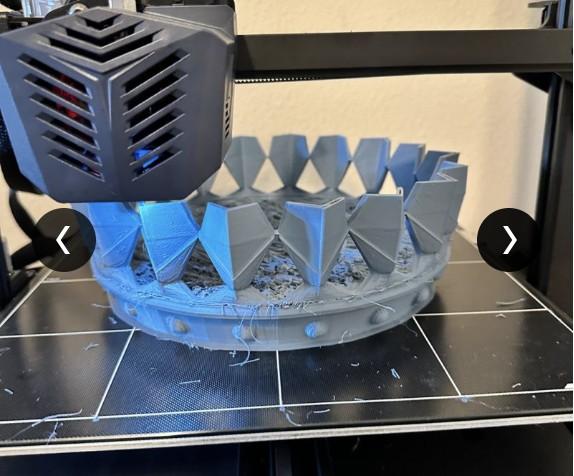 3D printer mid-print, building the spiked crown shape layer by layer.