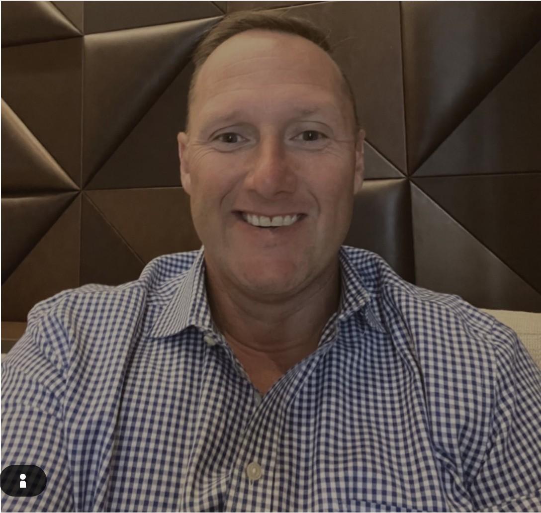 A smiling headshot-style photo of Wayne Partello.