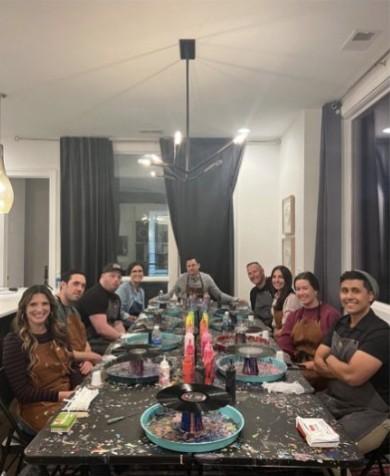 The CUENTO team seated around a long table during a paint-and-sip team retreat activity.