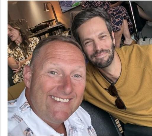 Wayne Partello taking a selfie with a colleague at a restaurant table